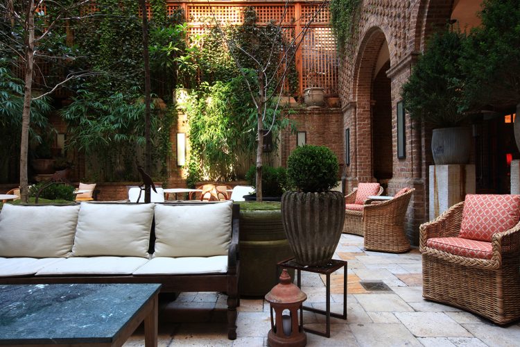 patio interno com moveis de madeira e plantas